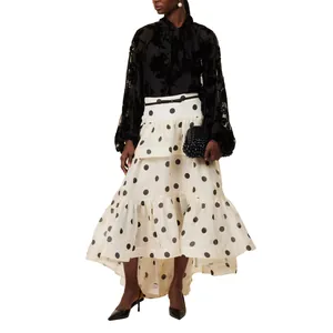 Ganzkörperansicht eines stilvollen gestuften Polka-Dot-Maxirocks mit schwarzer Bluse.