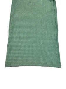 Detailed macro shot of the sage green textured knit fabric hem on a two-piece set.