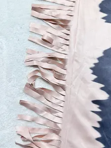 Close-up detail of the pink and grey color-block jumpsuit featuring stylish fringe tassels