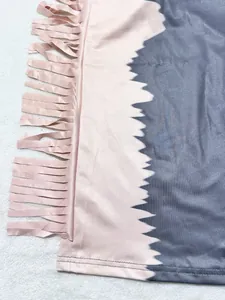 Close-up of pink and grey color block fabric with stylish tassel detail on smooth material