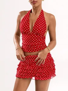 Detail shot showing the red and white polka dot halter top and ruffled mini skirt set.