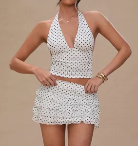 Close-up detail of sexy white polka dot halter neck top and ruffled mini skirt set