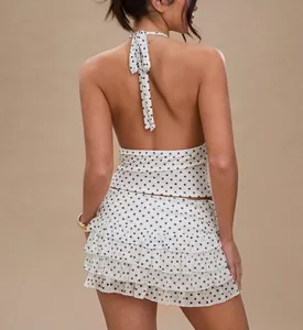 Detailed back view of white and black polka dot halter top with tiered ruffled mini skirt