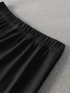 Gros plan sur la taille élastique d'un pantalon de détente noir montrant les détails