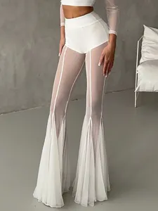 Detailed view of sexy white high-waisted flared pants with transparent mesh paneling