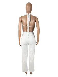 Vue arrière d'un ensemble blanc sexy dos nu avec haut licou et pantalon assorti.