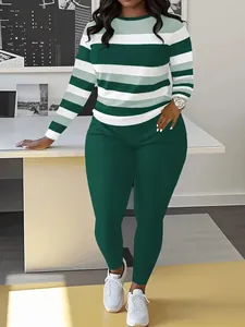 Détail d'un ensemble élégant pour femme comprenant un haut rayé vert et un pantalon assorti