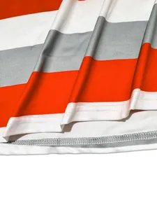 Vista macro de las costuras y los detalles de la tela en el conjunto de rayas naranja y gris
