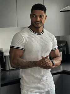 Detail of white ribbed muscle fit T-shirt with black striped collar and athletic cuffs