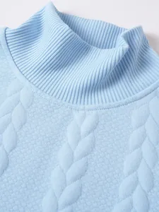 Primo piano di un maglione a collo alto celeste con trama a trecce e colletto a costine.