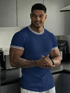 Close-up detail of a men's blue ribbed fitness t-shirt with striped trim accents
