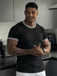 Detailed view of men's black ribbed athletic T-shirt with white striped crew neck.