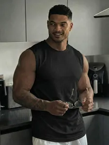 Breathable black mesh tank top for men, showcasing athletic fit in a lifestyle setting