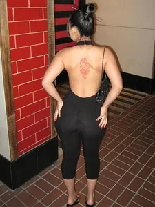 Rear view of sexy black backless slim fit jumpsuit with ribbed texture for women.