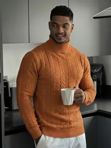 Primo piano del maglione a dolcevita arancione da uomo con motivo a trecce