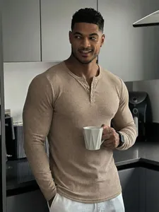 Homme musclé portant un t-shirt henley beige à manches longues dans une cuisine
