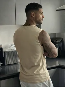 Close-up detail of a beige mesh sports tank top for men showing fit and fabric texture.