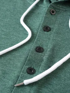 Close-up of button placket and heathered green fabric on a men's casual hoodie.