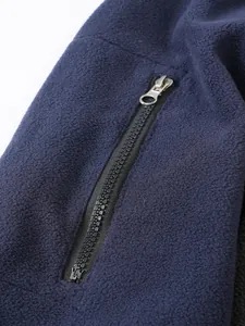 Detalle de la cremallera metálica en una sudadera de forro polar azul marino para hombre