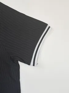 Detail view of black ribbed men's sports t-shirt showing white striped cuff and texture.