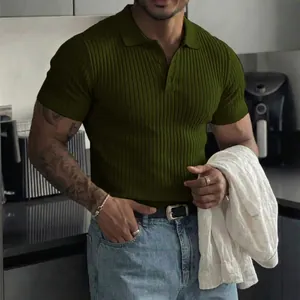 Detail view of a men's olive green ribbed short sleeve polo shirt worn by a model in a kitchen