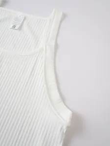 Close-up of white ribbed knit men's tank top showing fine texture and neck care label.