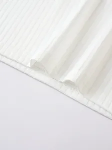 Close-up detail of white ribbed knit fabric with professional double-stitched hemline