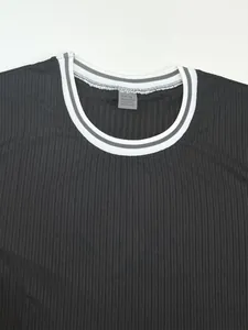 Close-up detail of black ribbed t-shirt collar with striped trim and size tag