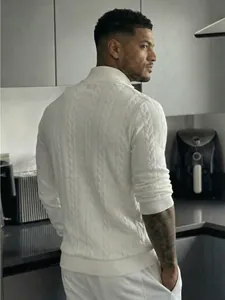 Vista posteriore di un uomo con un maglione bianco a trecce con collo alto in una cucina.