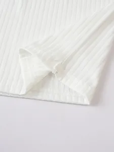 Macro view of white ribbed knit fabric texture showing precise hemline stitching