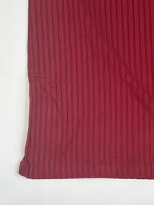 Close-up of the burgundy ribbed fabric texture on a men's quick-dry sports t-shirt.