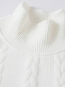 Dettaglio ravvicinato di un maglione a collo alto bianco con trama jacquard