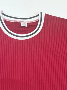 Close-up detail of a red ribbed sports t-shirt neckline with striped collar and tag.