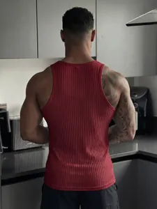 Back view of men's red ribbed gym tank top in a modern kitchen setting