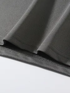 Close-up macro view of breathable grey mesh fabric texture and hemline on sports t-shirt