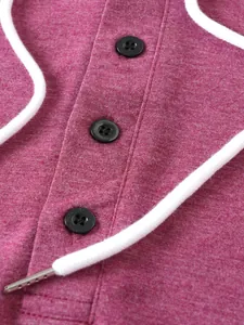 Close-up of buttons and white drawstring on a magenta men's sports hoodie.