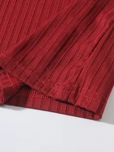Macro detail of red ribbed knit fabric and hem stitching on men's fitness tank top