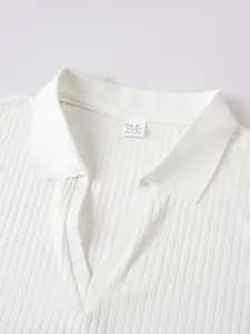 Close-up detail of a white men's ribbed polo shirt showing collar and V-neckline texture