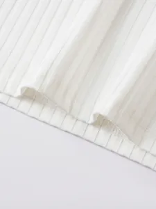 Close-up detail of white ribbed fabric texture and fine hem stitching on men's Polo vest