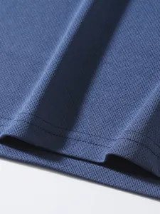 Close-up of breathable blue mesh fabric and hem stitching on men's sports tank top