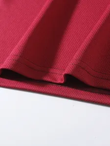 Close-up detail of breathable red mesh fabric and durable double-stitched sports hem.