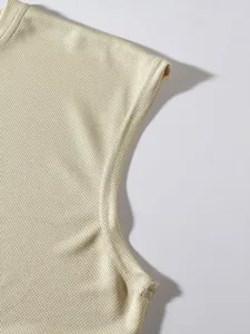 Detailed macro view of the stitching and mesh fabric on a cream sports tank top.