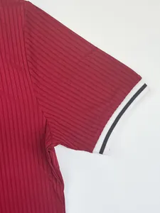 Detailed view of burgundy ribbed quick-dry fabric with black and white striped sleeve cuff.