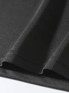 Macro detail of the breathable black mesh fabric and stitching on men's sports tank top