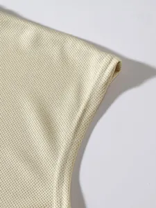 Close-up detail of the breathable mesh texture on a cream sleeveless sports tank top