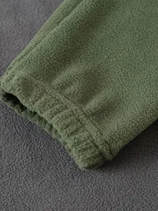 Primer plano del puño de la manga de forro polar verde oliva con textura y detalles.