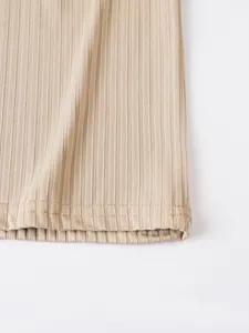 Close-up detail of the ribbed fabric and double-stitched hem on a beige Polo vest