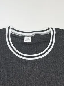 Close-up of crew neck with striped collar and size tag on ribbed grey T-shirt
