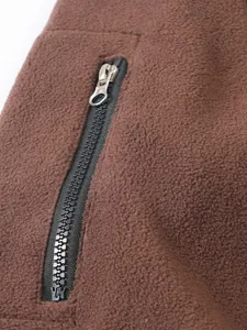 Primer plano del detalle de una sudadera de forro polar marrón con bolsillo de cremallera.