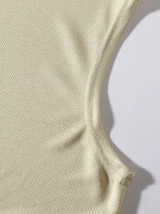 Macro view of breathable mesh fabric and seam detail on a men's sports tank top